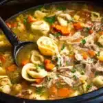 Bowl of Chicken Pot Pie Soup with Tortellini, topped with fresh herbs