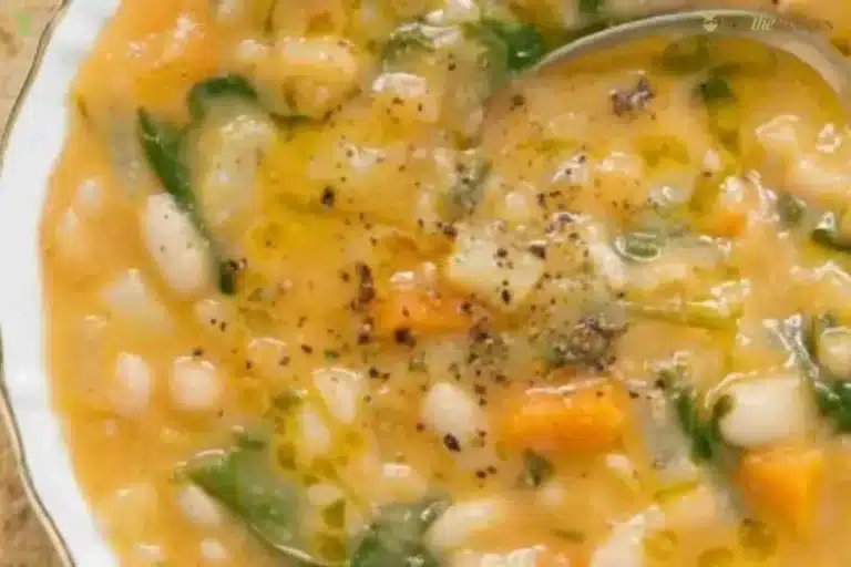 Bowl of creamy white bean soup garnished with herbs and bread