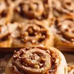 Freshly baked apple cinnamon roll topped with glaze and cinnamon