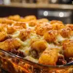 Chili Cheese Tater Tot Casserole topped with melted cheese and chili