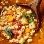 Bowl of classic Italian pastina soup with fresh herbs and vegetables