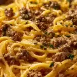 Delicious creamy garlic butter pasta topped with ground beef and herbs.