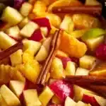 Warm and aromatic crock pot apple cider with spices in a cozy setting