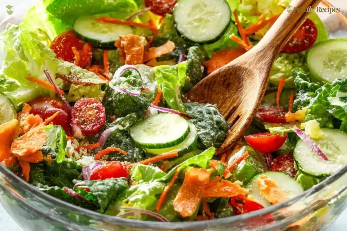 A vibrant classic house salad with lettuce, tomatoes, cucumbers, and dressing.