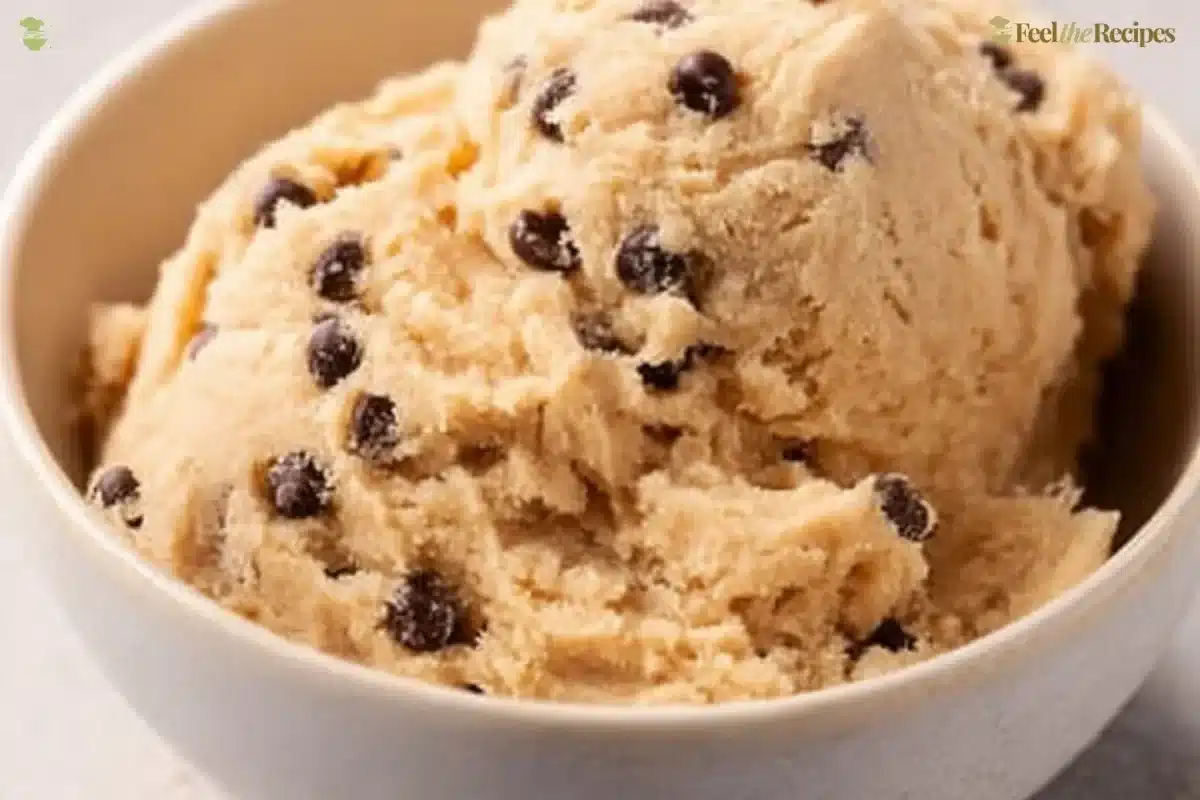 Bowl of edible chocolate chip cookie dough with chocolate chips and a spoon