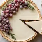 Festive white chocolate cranberry tart topped with fresh cranberries and white chocolate shavings