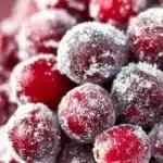 Bowl of sugared cranberries glistening with sugar crystals, ideal for festive decor.