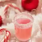 Festive candy cane shots with peppermint garnish in holiday-themed glassware