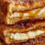 Delicious churro cheesecake topped with cinnamon sugar and whipped cream.