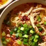 Classic ginger garlic chicken noodle soup garnished with fresh herbs