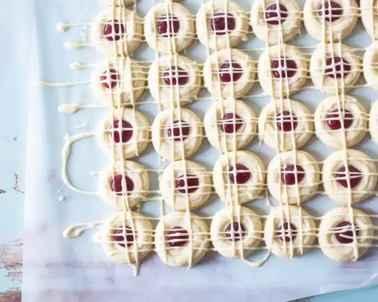 Soft and chewy raspberry cookies drizzled with white chocolate and filled with raspberry jam.