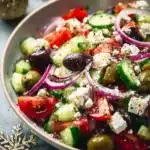 A colorful Greek salad with fresh vegetables, feta cheese, and olives