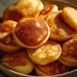 Breakfast pancake poppers served on a plate with syrup and berries