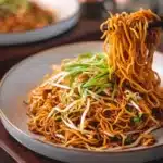 Plate of classic Chinese fried noodles with vegetables and spices
