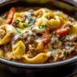 Crock Pot Cheesesteak Tortellini served in a bowl with cheese and herbs