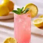 Cupid’s Pink Lemonade Mocktail served in a glass with fresh lemons