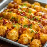 Loaded tater tot skewers topped with cheese and bacon