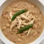 Delicious creamy white chicken chili in a slow cooker served with toppings