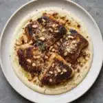 Crockpot Garlic Parmesan Pork Chops served on a plate with herbs