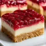 Delicious no-bake rhubarb cheesecake squares on a dessert plate