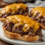 Delicious slow cooker birria sliders served with toppings and side dishes.