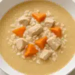 Bowl of Slow Cooker Chicken Wild Rice Soup garnished with herbs