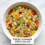Colorful summer-inspired orzo pasta salad with fresh vegetables and herbs