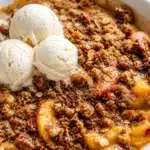 Fresh peach crisp topped with a buttery oat crumble, perfect for summer desserts.