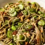 Chili crisp noodle salad with cucumbers and vibrant dressing served in a bowl.