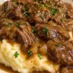 Tender slow cooker beef tips simmered in rich gravy served in a bowl.
